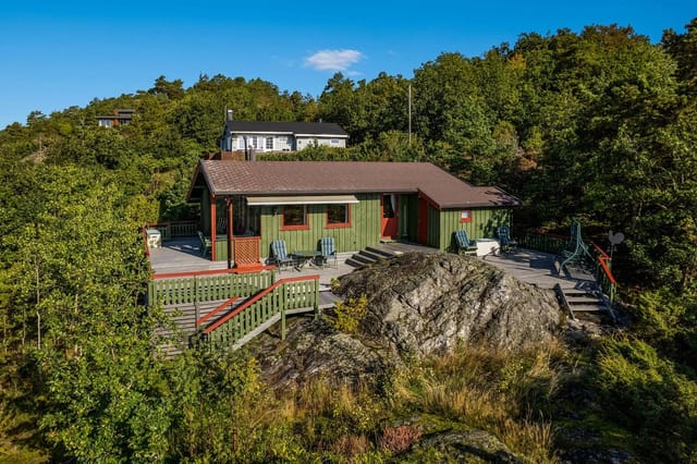 The terrace that stretches around the entire cabin invites both coziness with a view, cooking at the outdoor kitchen, or an outdoor shower behind the cabin.