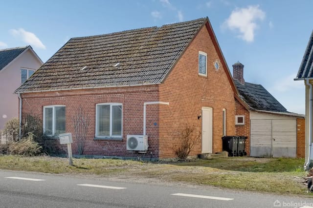 Red brick house with tiled roof, garage, and main entrance along the street