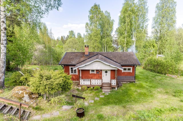 Front view of the house with garden and lake in the background
