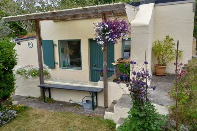 Front view of the WWII bunker tiny house and garden
