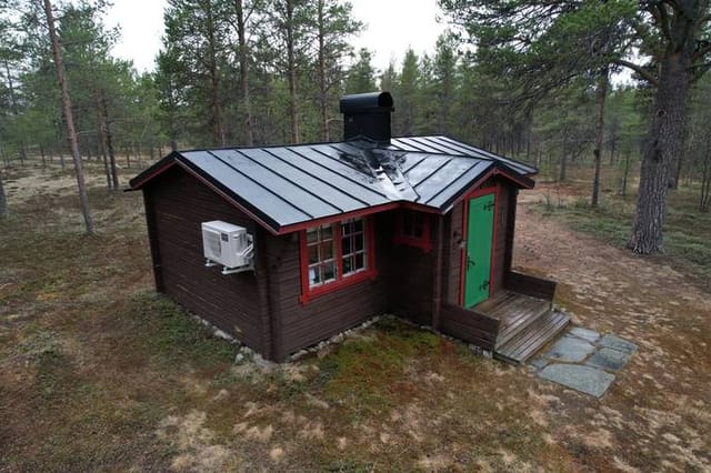 Exterior view of the log cabin and surrounding nature