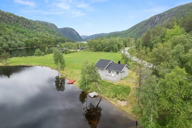 The cabin is located in scenic surroundings with a shoreline at Brelandsvatnet